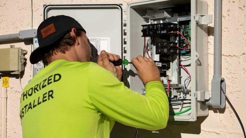 An electrician running new cable from the breaker panel to add a dedicated circuit