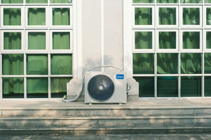 An HVAC technician connecting refrigerant lines to a new outdoor unit to replace an AC condenser