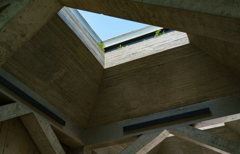 A roofer lifting a new unit into the curb to replace a skylight and seal the flashing