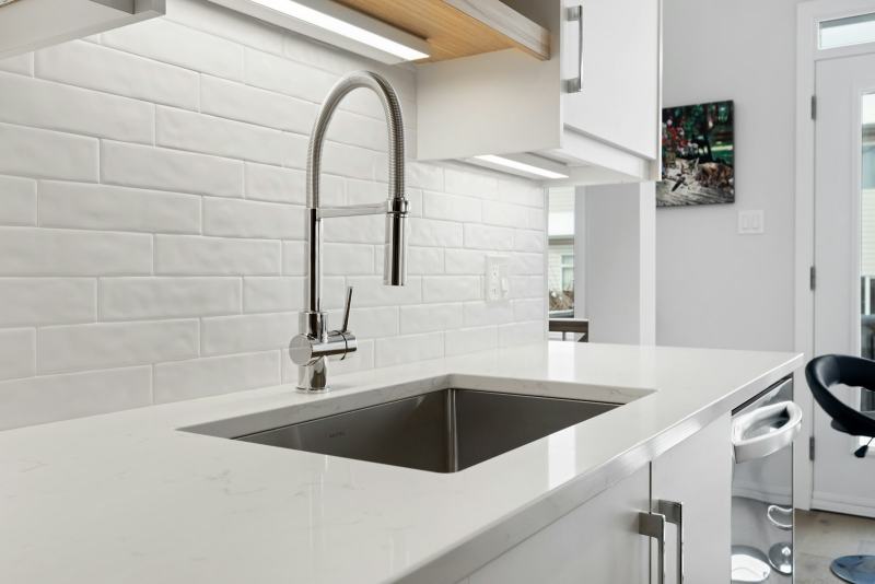 A plumber running new drain pipe through the floor to move a kitchen sink to an island